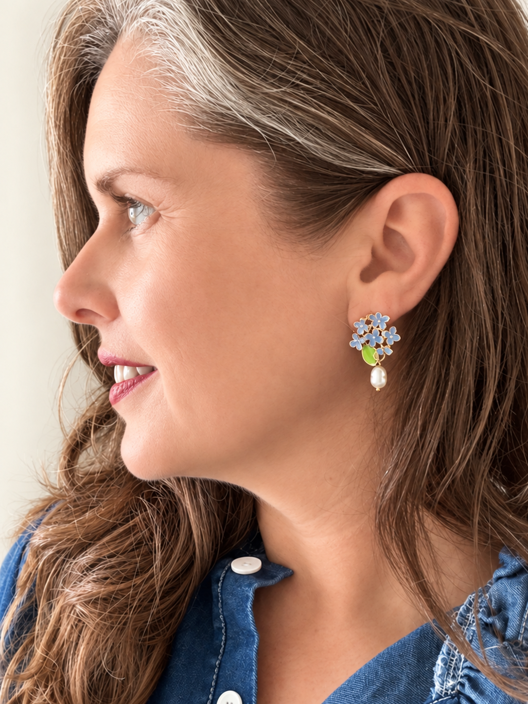 Jenny wearing blue hydrangea earrings with a denim shirt