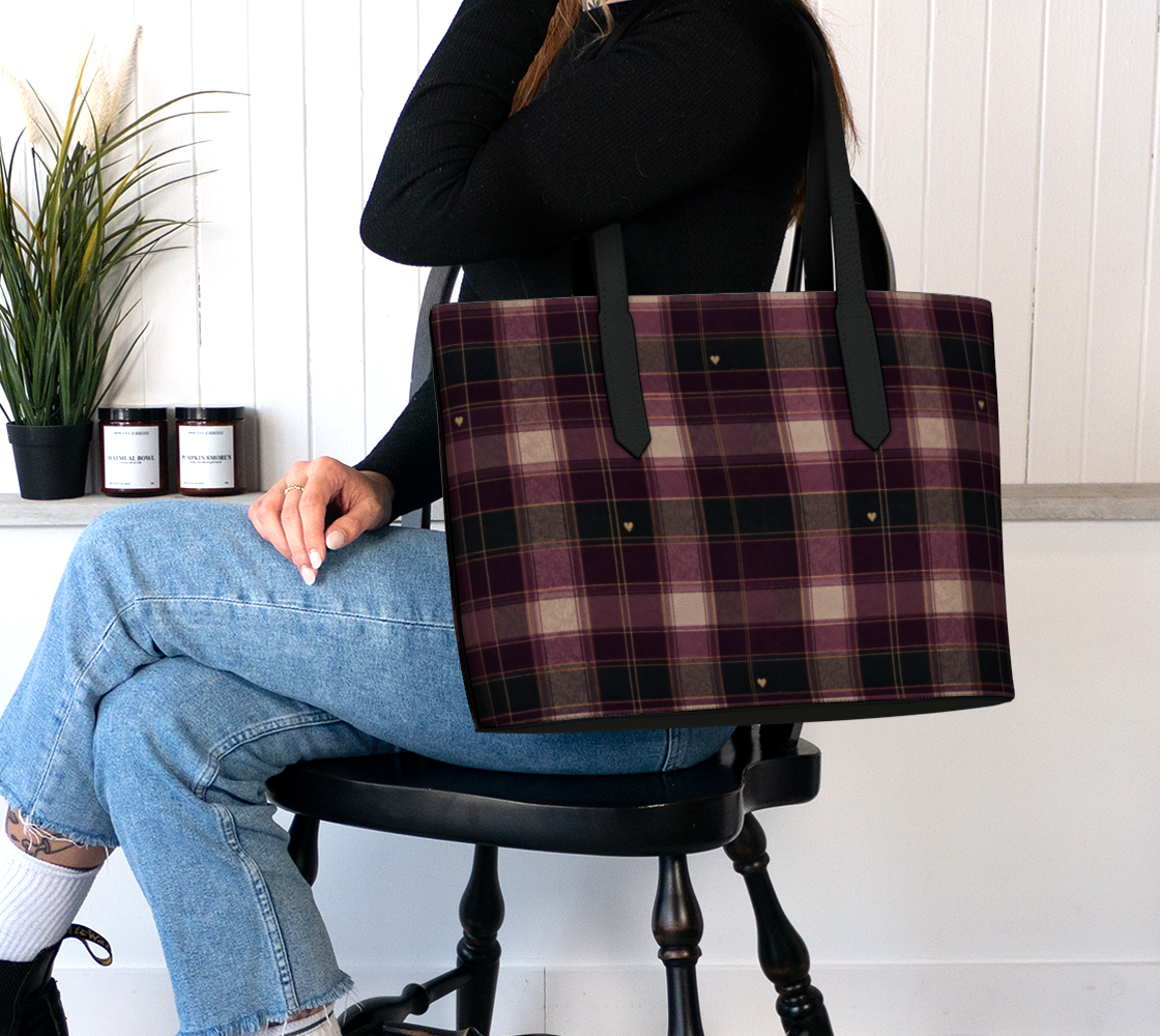 Model carrying the Falling for You plaid heart vegan leather tote with a black sweater and blue jeans.