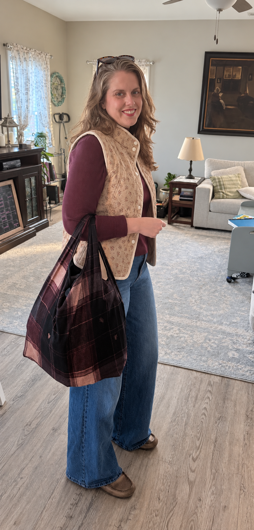Jenny wearing the Meadow Bloom Quilted Cotton Vest over a plum top with wide-leg jeans and a plaid tote.