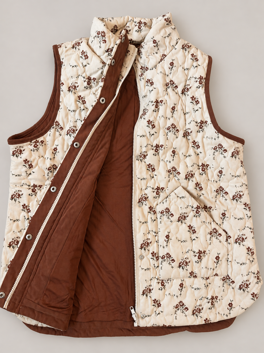 Meadow Bloom Quilted Zip Vest opened to show its brown lining, cream zipper and silver snap fasteners.